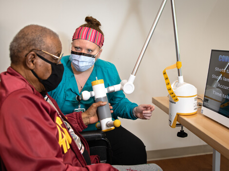 Therapist working with stroke rehabilitation patient using stroke recovery technology.