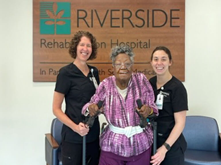 Regina Montague stands with her therapists.